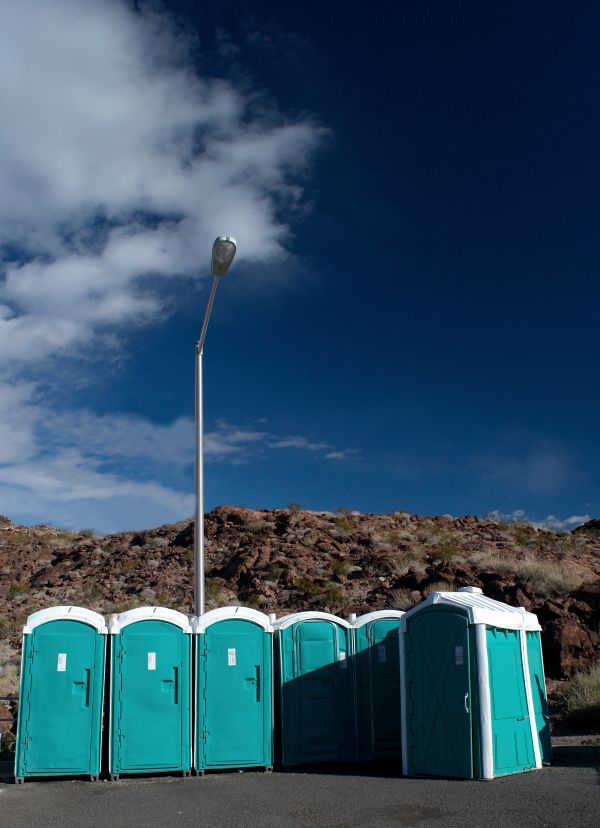Service technician pumping and restocking a porta potty in Fort Lauderdale