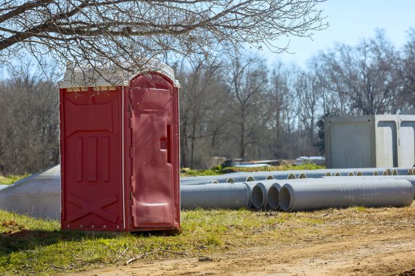 Construction site porta potty placed beside site fencing in South Florida